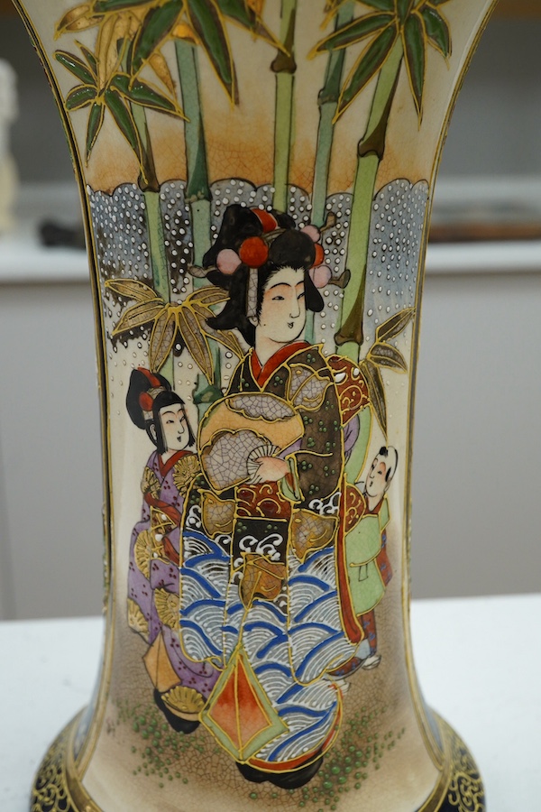 A 20th century Japanese Satsuma pottery trumpet vase decorated with figures, 32cm high. Condition - crazed